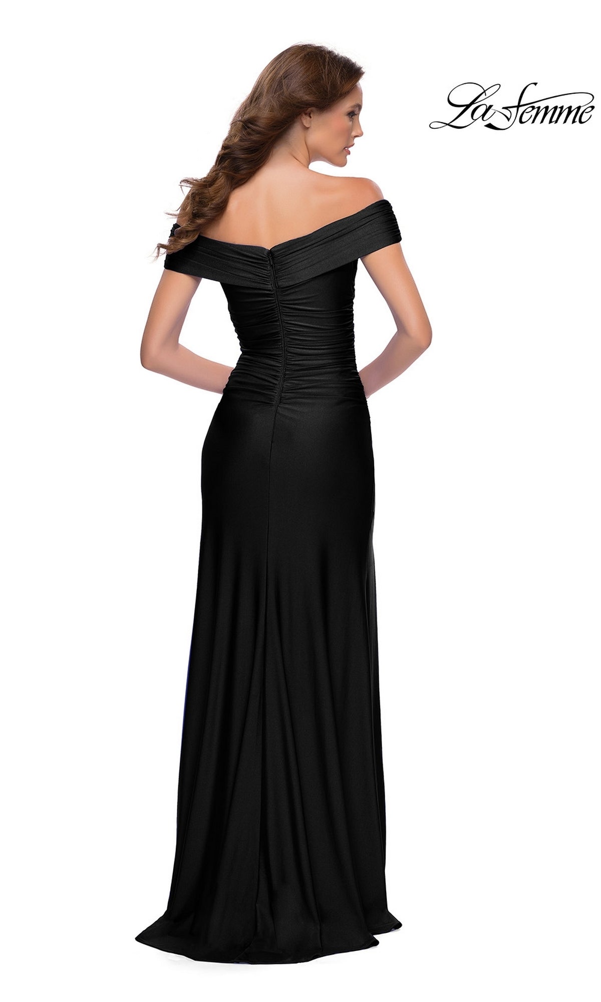 Woman in a floor-length black La Femme Long Prom Dress 29781, featuring an off-the-shoulder design, shown from the back with zip closure and elegant ruched detailing.